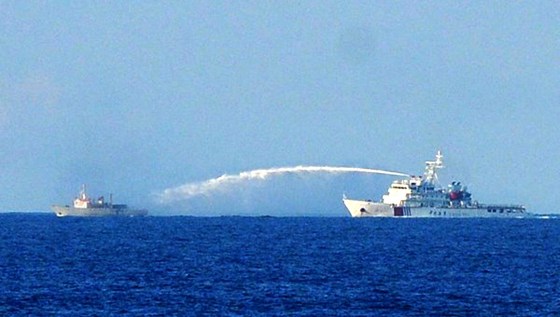This picture taken on June 2, 2014 shows a Chinese Coast Guard ship (R) using a water cannon to attack a Vietnamese Fisheries Surveillance boat near to the site of the Chinese oil rig in disputed waters of the South China Sea off Vietnam's central coast. China fired water cannons at a Vietnamese vessel and damaged another of Hanoi's ships, Chinese state media said on June 3, in the latest confrontation over disputed waters in the South China Sea.