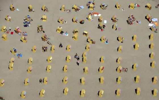 Image: People take a sunbath in their beach chairs at a beach in Travemuende