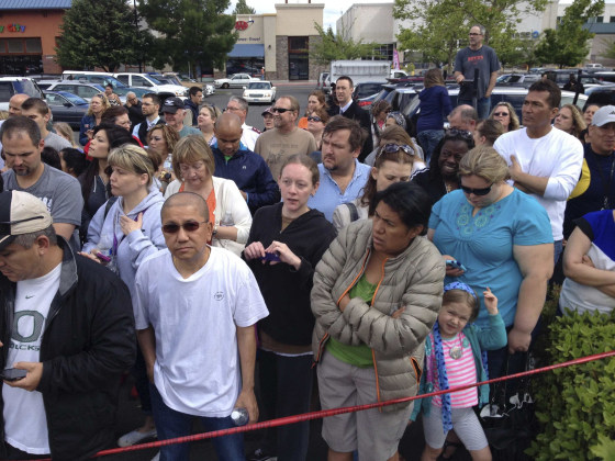 Image: Parents wait behind police tape for students from Reynolds High School to arrive by bus in Troutdale, Oregon