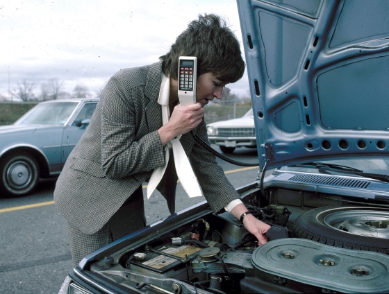 Image: A stranded motorist calls a service station from an in-car cellular phone, 1983, in a staged photo from General Electric.