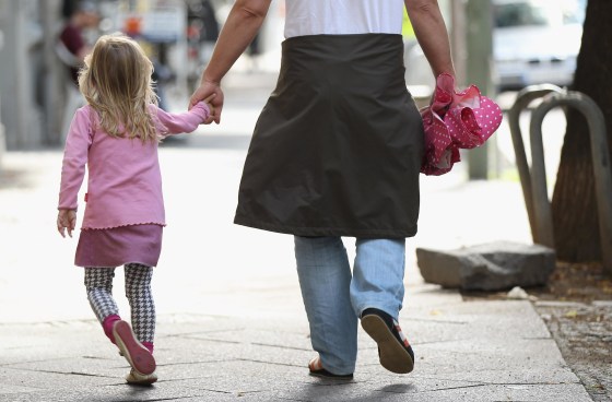 Image: A father and daughter walk in a city center