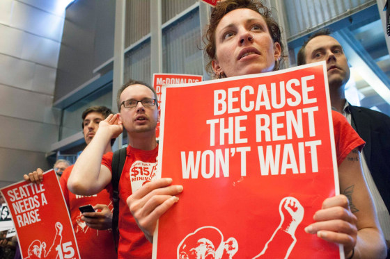 Image: Labor activists Ginger Jentzen and Jeremy Thornes listen during a Seattle City Council meeting in which the council voted on raising the minimum wage to $15 per hour in Seattle, Washington