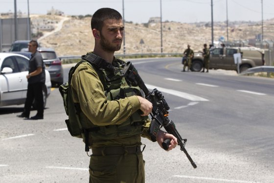 Image: An Israeli soldier stands guard at a junction near the West Bank city of Hebron