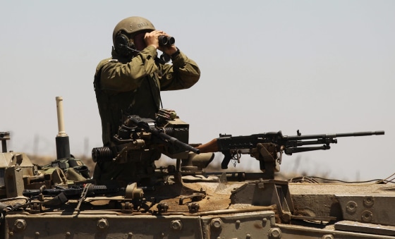 Image: An Israeli soldier uses binoculars on the Israeli-Syrian border in the Golan Heights