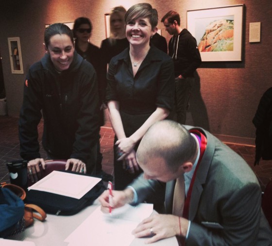 Amy Fowler, center, and Pidge Winburn, left, look on as their officiant Cliff Rosky signs paperwork after their marriage on Dec. 23.