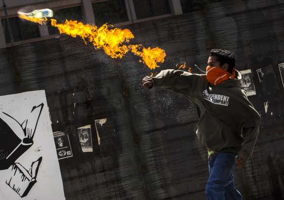 Image: A protester throws a molotov cocktail at Bolivarian National Police