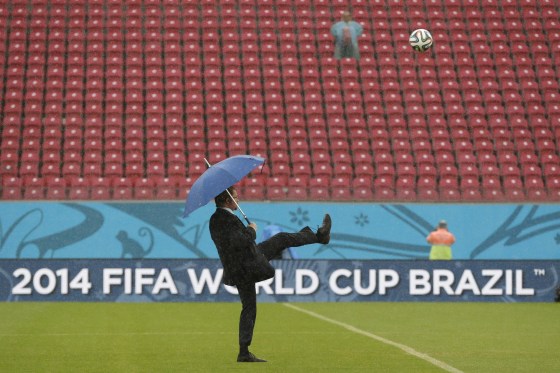 A FIFA official tests the pitch as rain pours down prior to the group G World Cup soccer match between the USA and Germany at the Arena Pernambuco in Recife, Brazil, on June 26.