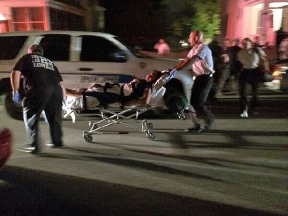 EMTs tend to one of the shooting victims on Midland Street in Lowell.