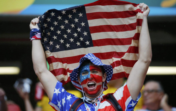 A fan of the U.S. cheers while holding the national flag before their 2014 World Cup Group G soccer match against Germany at the Pernambuco arena in Recife June 26, 2014. REUTERS/Laszlo Balogh (BRAZIL - Tags: SOCCER SPORT WORLD CUP)