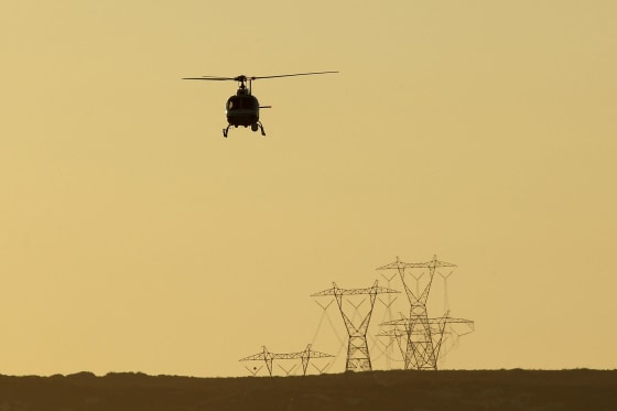 Image: A helicopter patrols as agents carry out special operations near the US-Mexico border fence