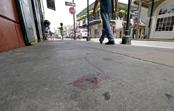 Image: Blood stains are seen on the sidewalk at the scene of a shooting