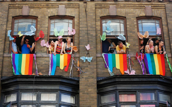 Image: People watch from windows during the \"WorldPride\" gay pride Parade in Toronto