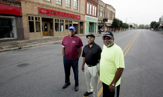 Image: Herman Williams , Desmond Wright and Albert Shade stand outside of now the closed McLellan's department store almost fifty years after they staged a sit-in there to protest the whites-only lunch counter.
