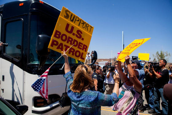 Image: Demonstrators picketing against the arrival of undocumented migrants who were scheduled to be processed at the Murrieta Border Patrol Station block the buses carrying the migrants in California