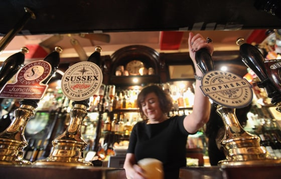 Image: A barmaid pulls a pint in The Harp pub on the day it was named as the Campaign for Real Ale's national pub of the year on Feb. 16, 2011 in London, England.