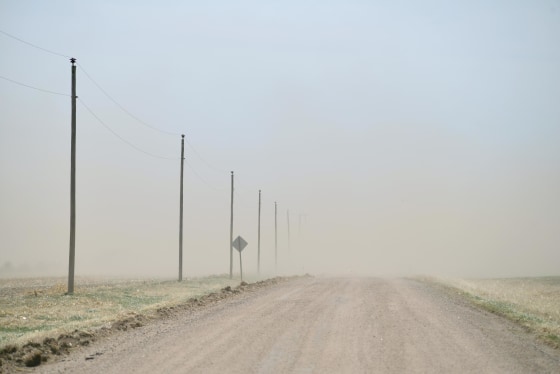 Image: The relentless Kansas wind strips a dry, bare field and sends the topsoil to obscure a county road