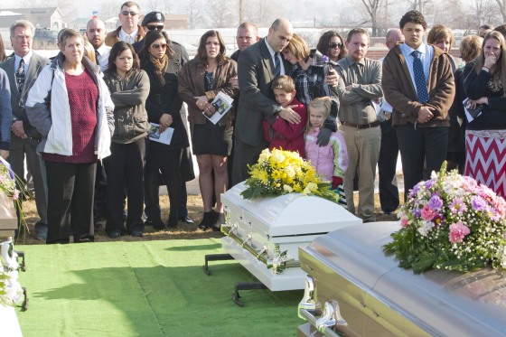 Image: Provo Police Department officer Dan Smith comforts his wife, Bre Smith, and his children at the funeral for Kelly Boren, her children, Joshua \"Jaden\" Boren, Haley Boren and her mother, Marie King at Lindquist's Memorial Park in Layton, Utah