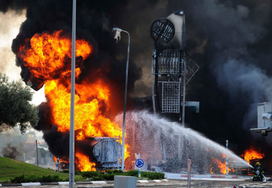 Firefighters extinguish a fire that broke out after a rocket hit a gas station in the southern Israeli city of Ashdod on July 11, 2014. 