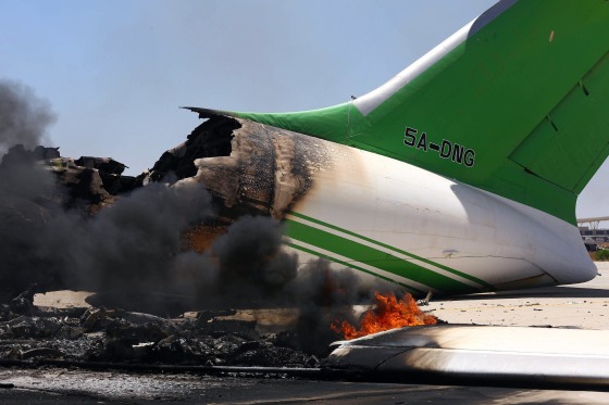 Image: Flames and smoke billowing from an airplane at the Tripoli international airport in the Libyan capital