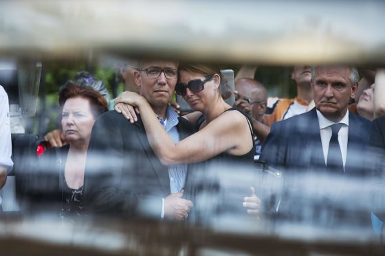 Image: Family members of the victims killed in Malaysia Airlines Flight MH17 plane disaster are seen reacting through the window of a hearse carrying the victims' bodies, as they arrive at the Korporaal van Oudheusden barracks in Hilversum
