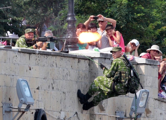 Image: People watch Russian servicemen taking part in a naval parade rehearsal in the Crimean port of Sevastopol
