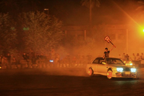 Young Iraqi men gather to watch souped up cars intentionally spin out and skid: a dangerous sport called “drifting.”