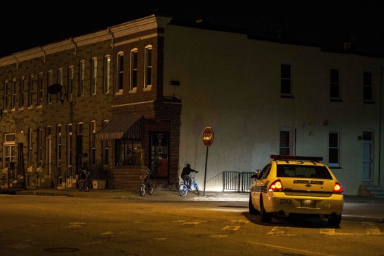 Image: Police patrol a residential neighborhood in east Baltimore minutes after a curfew law took effect in Baltimore