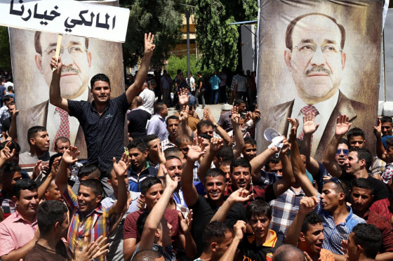 Supporters of Iraqi Prime Minister Nouri al-Maliki carry his pictures and placards reading "Maliki is our choice" in Arabic in Baghdad on Monday.