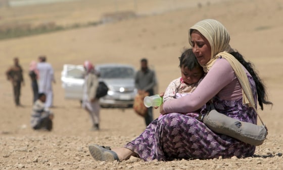 Image: A displaced woman and child from minority Yazidi sect, fleeing violence from forces loyal to Islamic State in Sinjar town, ride truck and donkey as they make way towards Syrian border, on outskirts of Sinjar mountain