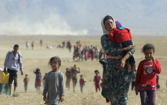 Image: Displaced people from the minority Yazidi sect walk toward the Syrian border