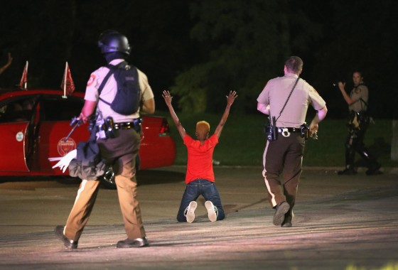 Police surround and detain two people in a car on Aug. 13, 2014 in Ferguson, Mo. Ferguson is experiencing its fourth day of unrest after following the shooting death of teenager Michael Brown on Saturday. Brown was shot and killed by a Ferguson police officer. 