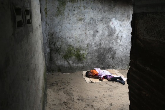 A very sick Saah Exco, 10, lies in a back alley of the West Point slum on Aug. 19 in Monrovia, Liberia. The boy was one of the patients that was pulled out of a holding center for suspected Ebola patients when the facility was overrun by a mob on Saturday.