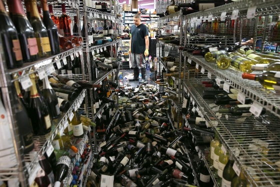 A worker looks at a pile of wine bottles that were thrown from the shelves at Van's Liquors following a reported 6.0 earthquake on Aug. 24, 2014 in Napa, California.