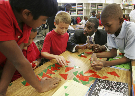 Image: Hayward Jean, 27, center, works with his fourth grade single gender students during a math lesson