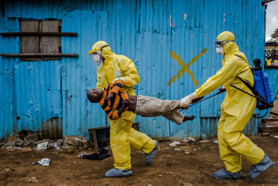 Medical staff carry James Dorbor, 8, suspected of having Ebola, into a treatment facility in Monrovia, Liberia, on Friday. The fear sparked by the Ebola outbreak is having a serious economic impact on Guinea, Liberia and Sierra Leone, three nations already at the bottom of global economic and social indicators. 
