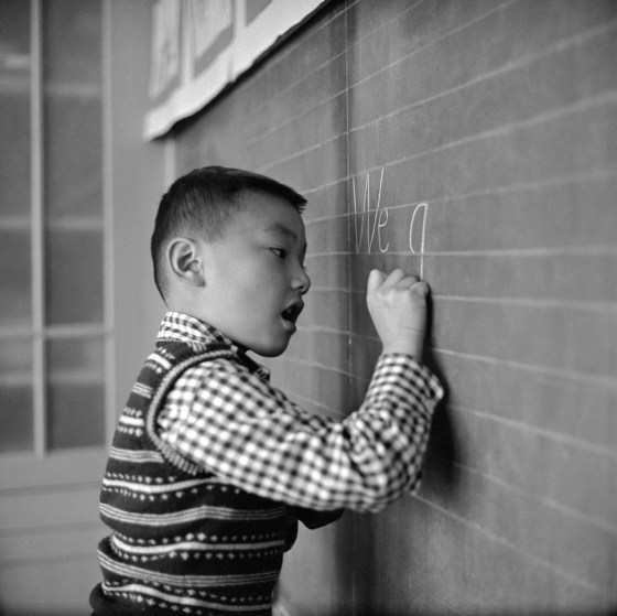 A Chinese boy writes carefully on the blackboard during an English lesson at the Commodore Stockton School in San Francisco's Chinatown in 1955.