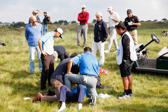 Image: Golfer Fabrizio Zanotti of Paraguay is attended to by medical staff after being struck with a ball