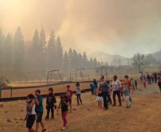 Children are evacuated from the Weed Elementary School in Weed, Calif., as a wildfire burns nearby on Sept. 15, 2014.