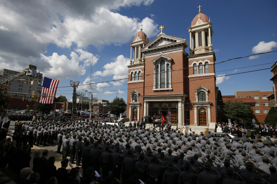 An honor guard carries the casket of Pennsylvania State Trooper Cpl. Bryon Dickson after his funeral service, on Sept. 18, in Scranton, Pa.