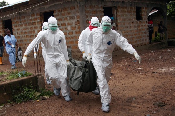 Image: Liberian nurses carry the body of an Ebola victim from a house for burial in the Banjor Community on the outskirts of Monrovia, Liberia