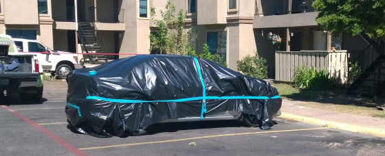 A car is wrapped in plastic Oct. 3 in the parking lot as a hazmat team prepared to clean the apartment in Dallas where Ebola patient Thomas Eric Duncan had been staying.
