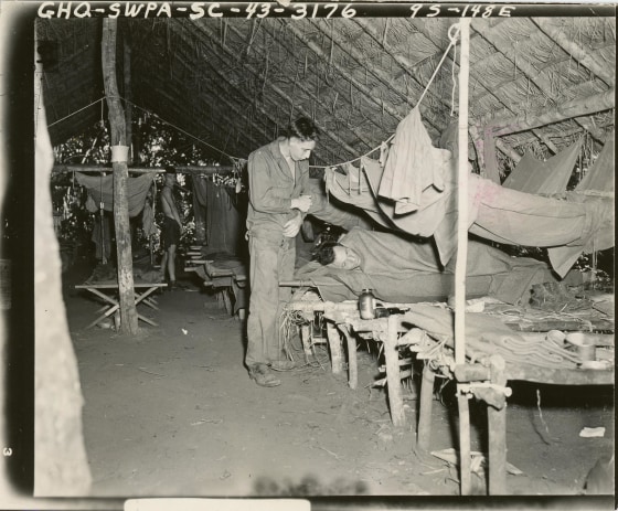 A soldier cares for another malaria-stricken soldier at a portable hospital in New Guinea in 1943. Some of the ill troops in New Guinea also wound up in the experiments.