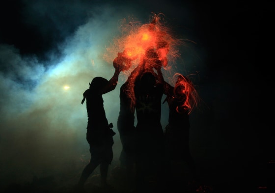 Image: Balinese men lashing burning coconut husks off each other during 'Mesabatan Api'