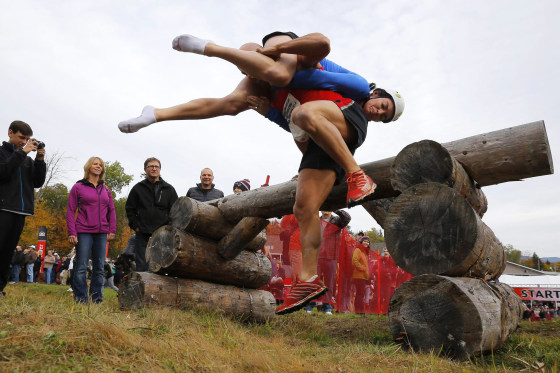 Image: Jeff and Kelly Lyons clear the first obstacle while competing in the North American Wife Carrying Championship at Sunday River ski resort in Newry