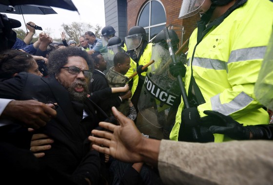 Image: Activist Cornel West is knocked over during a scuffle with police during a protest at the Ferguson Police Department in Ferguson