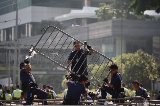 Police officers remove barricades of pro-democracy protestors in the Admiralty district of Hong Kong on October 14, 2014.