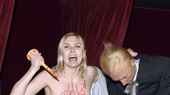 Image: An activist from the feminist group Femen holding a wax statue representing Russian President Vladimir Putin