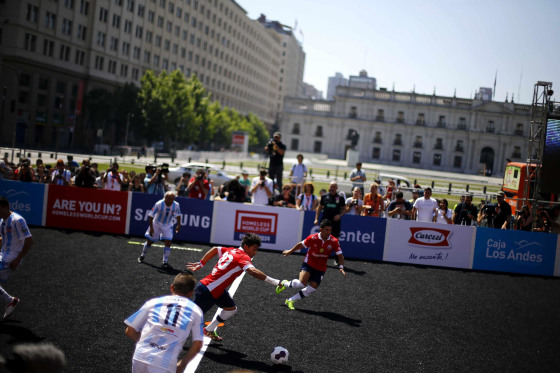 Chilean players and Argentinian players fight for the ball during 12th Homeless World Cup soccer tournament in front of the government palace in Santiago October 19, 2014. Some 52 teams, including 12 women teams, take part in the tournament, which starts on Sunday until October 26th. Participants of the tournament are either asylum seekers, homeless or in drug or alcohol rehabilitation treatment. REUTERS/Ivan Alvarado (CHILE - Tags: SPORT SOCCER SOCIETY DRUGS POVERTY)