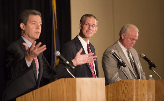 Democratic gubernatorial candidate Paul Davis, center, glances toward Kansas Gov. Sam Brownback, left, he answers a question during a gubernatorial debate, Friday, Sept. 19, 2014, in Overland Park, Kan. (AP Photo/The Lawrence Journal-World, Nick Krug)