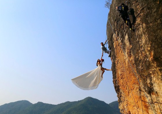 Image: Zheng Feng, an amateur climber takes wedding pictures with his bride on a cliff in Jinhua